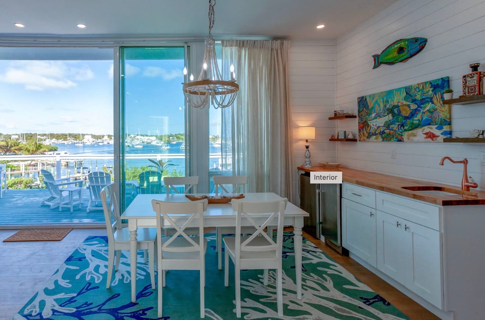 Bar and kitchen area with white cabinetry and original art