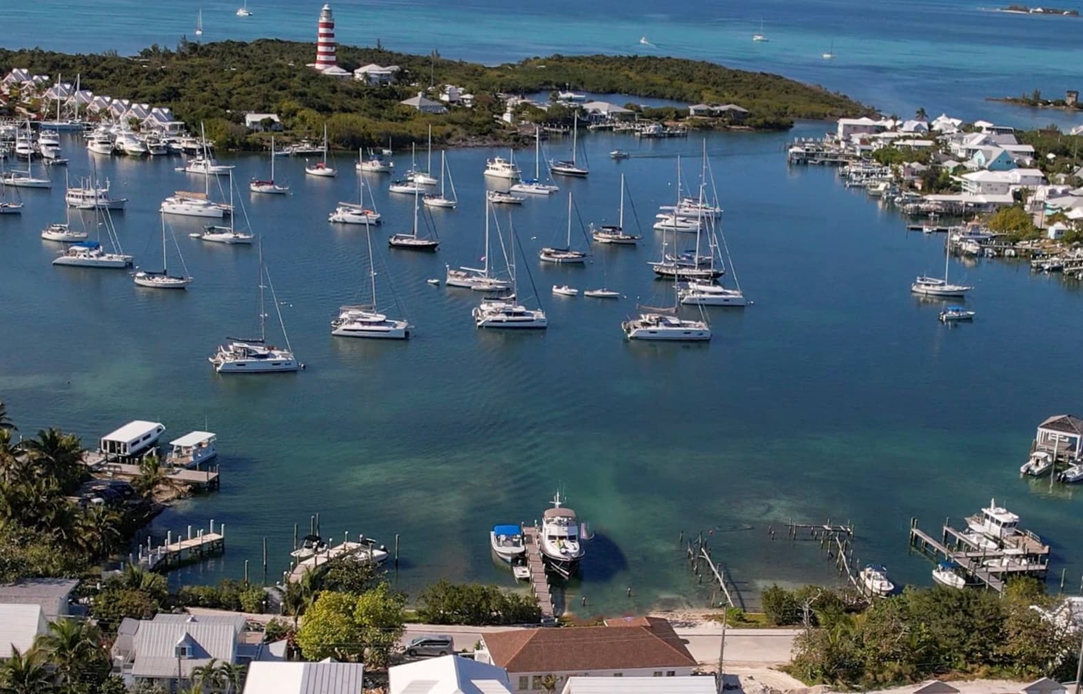 Aerial view of Hope Town harbour with sailboats and lighthouse