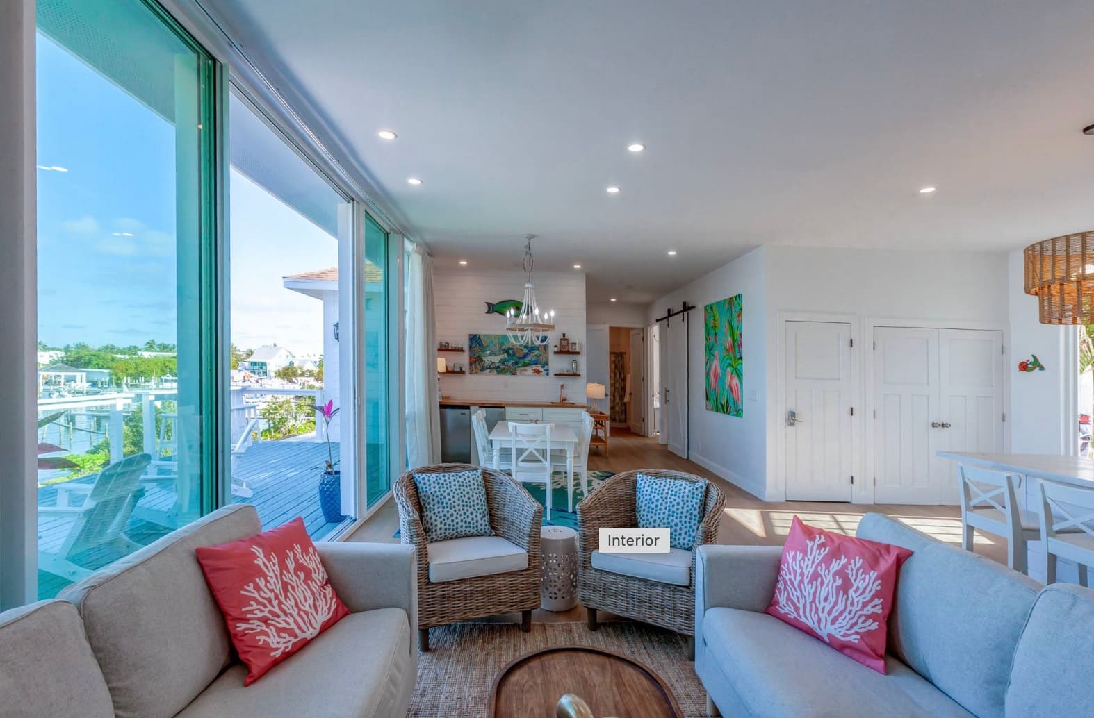 Open sitting area with harbour views and coral pillows