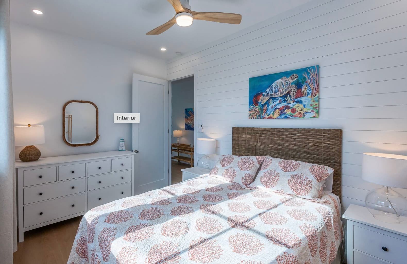 Guest bedroom with coral pattern bedding and artwork